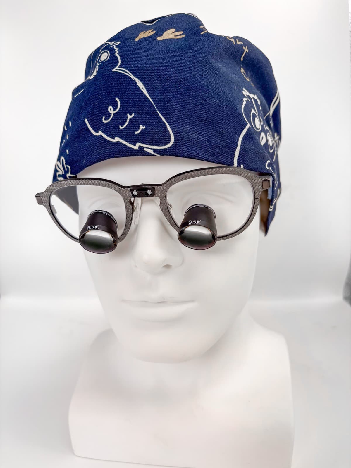 Mannequin head wearing ACUVIEW straight-through loupes, showing the custom fit